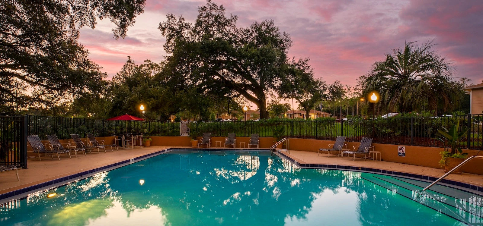 Beautiful community swimming pool, decoratively lit at sunset